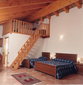 1 dormitorio con 2 camas y escalera de madera en Il Castagneto, en Teolo
