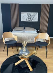 a bedroom with a bed with two chairs and a table at Hotel Europe Brig in Brig