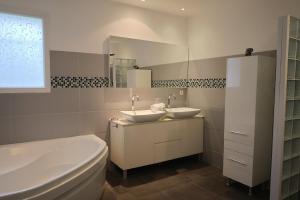 une salle de bain avec deux lavabos et un WC et un miroir dans l'établissement Villa Lili Rose - Jacuzzi et Rivière à 3 min à pieds, à Zonza 31 autres photos