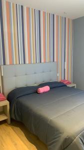 a bed with a pink pillow on top of it at Appartamento Meriggio in Gabicce Mare