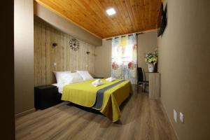 1 dormitorio con 1 cama con manta amarilla en Happy House en Faro