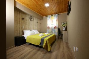 um quarto com uma cama com um cobertor amarelo em Happy House em Faro