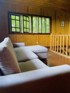 uma sala de estar com dois sofás e duas janelas em Romantic Refuge under the Stars, Villa BellaVista em Tamboril