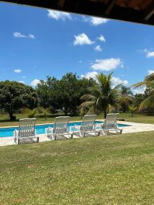 a group of chairs sitting next to a swimming pool at Chale Blue Lodge in São Pedro