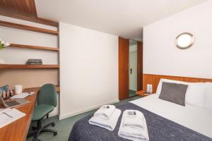 a hotel room with a bed and a desk and a computer at The Quigley Residence in Limerick