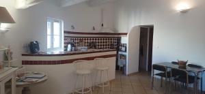 a kitchen with a counter and stools in a room at Duplex de charme avec terrasse au coeur du village in Lorgues