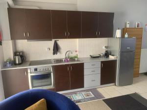 a kitchen with brown cabinets and a stainless steel refrigerator at Gerard Luxury apartment in Patra