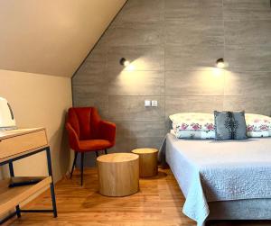 a bedroom with a bed and a red chair at WERONIKA Murzasichle in Murzasichle