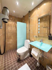 a bathroom with a toilet and a blue sink at Best Western Hotel Bentleys in Stockholm