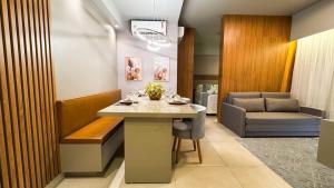 a waiting room with a table and a couch at Apartamento com aconchego e modernidade Apogeo in Ribeirão Preto