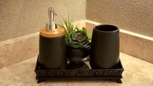 a black tray with a faucet and a plant at Apartamento com aconchego e modernidade Apogeo in Ribeirão Preto