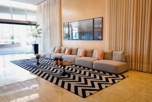 a living room with a couch and a rug at Apartamento com aconchego e modernidade in Ribeirão Preto