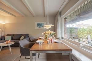 a living room with a table and a couch at Haus Wattblick EG in Braderup