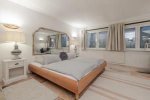 a bedroom with a large bed and a mirror at Haus Wattblick EG in Braderup +43 photos