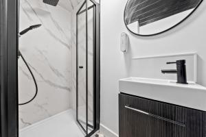 a bathroom with a shower and a sink and a mirror at Comfortable 4 Bedroom Apartment - Hawick in Hawick +32 photos