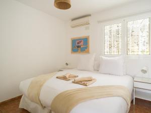 een witte slaapkamer met een bed met twee handdoeken erop bij Nueva Suecia By CanariasGetaway in San Agustin