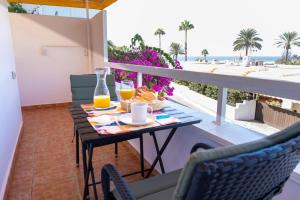 een tafel met eten en drinken op een balkon met uitzicht op de oceaan bij Nueva Suecia By CanariasGetaway in San Agustin
