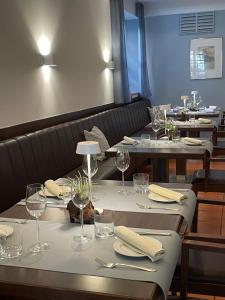 a row of tables with wine glasses and napkins at Altmann's Stube in Erlangen