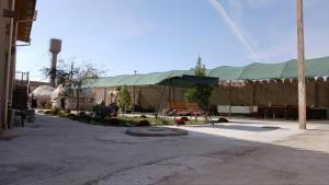 a large building with a green roof in a courtyard at Deshon Qala Guest House in Khiva