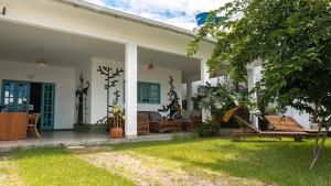 ein weißes Haus mit Terrasse und Garten in der Unterkunft Casa Azul Maragogi in Maragogi