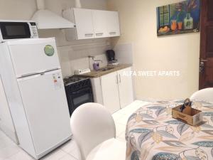 a kitchen with a white refrigerator and white cabinets at ALFA SWEET APARTS in Formosa +18 photos