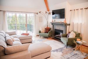 a living room with a couch and a fireplace at Sage & Pine Modern Townhome in Klamath Falls
