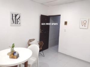 a white dining room with a table and a door at ALFA SWEET APARTS in Formosa