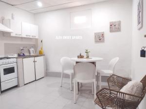 a kitchen with a table and chairs in a room at ALFA SWEET APARTS in Formosa