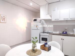 a white kitchen with a table and a white refrigerator at ALFA SWEET APARTS in Formosa