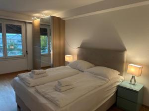 um quarto com uma grande cama branca com toalhas em Apartments in Zurich West-Eichbühlstr 62-68 em Zurique