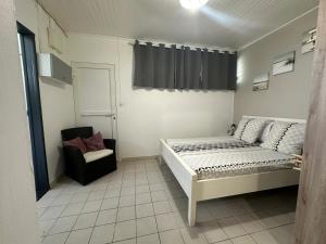une petite chambre avec un lit et une chaise dans l'établissement Studio accueillant aux Trois-Îlets, 30 m², piscine partagée, à Lazaret 27 autres photos