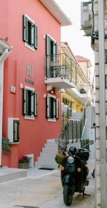 een scooter geparkeerd voor een rood gebouw bij RoDous Luxury Apartments Preveza in Preveza