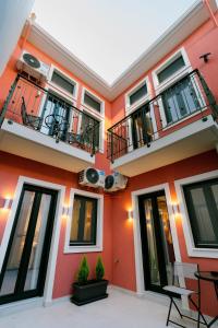 een oranje gebouw met twee balkons en ramen bij RoDous Luxury Apartments Preveza in Preveza