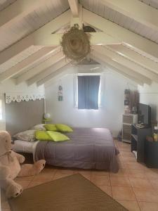 a bedroom with a large bed and a teddy bear at Villa confortable à Les Trois-Îlets avec piscine privée in Lazaret