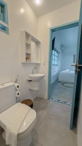 ein Bad mit einem WC, einem Waschbecken und einem Bett in der Unterkunft Casa Azul Maragogi in Maragogi