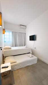 Zimmer mit 2 Betten und einem TV. in der Unterkunft Casa Azul Maragogi in Maragogi