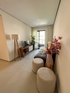 a large living room with a couch and a vase at RUA PLANA, 2qts, 2 banh, VARANDA c CHURRASQUEIRA, estacionamento, ELEVADOR, portaria in São Lourenço