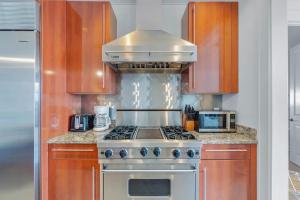 a kitchen with a stove and a microwave at Elegant Three Bedroom Condo Near Rosemary Beach in Rosemary Beach