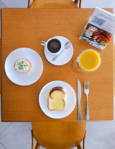 a table with plates of food and a cup of coffee at Luxo à beira-mar com Café no Solar Tambaú in João Pessoa +12 photos