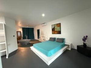 une chambre avec un lit bleu et une baignoire dans l'établissement The Secret Oasis Villa, à Cap Malheureux