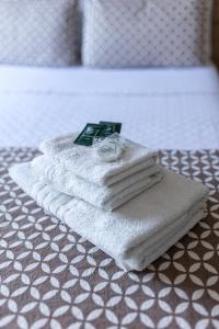 Una pila de toallas encima de una cama en JHS Palace Hotel, en Boa Esperança