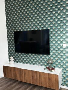 a living room with a tv on a wall at Lovely 1BR & 1LR Apartment, Only 15 Min Walk to City Center in Ghent