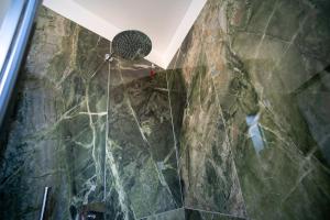 un bagno con doccia con parete in pietra di 15 Nevoso Palace a Milano