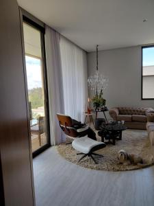 a living room with a couch and a table and chairs at Casa temporada alto padrão in Nova Lima
