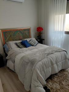 a bedroom with a large bed with blue pillows at Casa temporada alto padrão in Nova Lima