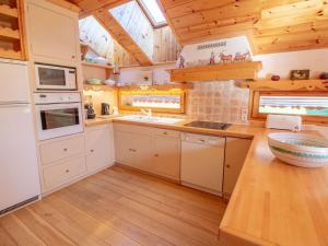 a kitchen with white cabinets and a wooden floor at Spacieux Duplex en Centre Station avec Balcon et Wi-Fi - FR-1-688-35 in Méribel +7 photos