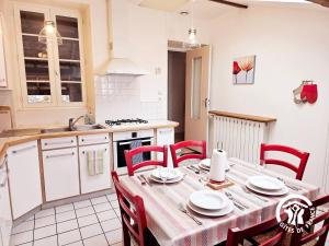 a kitchen with a table with red chairs in a kitchen at Le Logis du Berger in Camarès