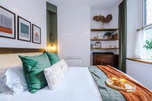 a bedroom with a white bed with green pillows at Rufloreo Flats 1 - central gem in Buxton