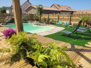 a backyard with a swimming pool and a wooden deck at Bel des Prés - Cocùn - Piscine partagée in Carquefou