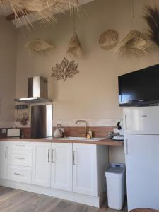 a kitchen with white cabinets and a sink at Bel des Prés - Cocùn in Carquefou